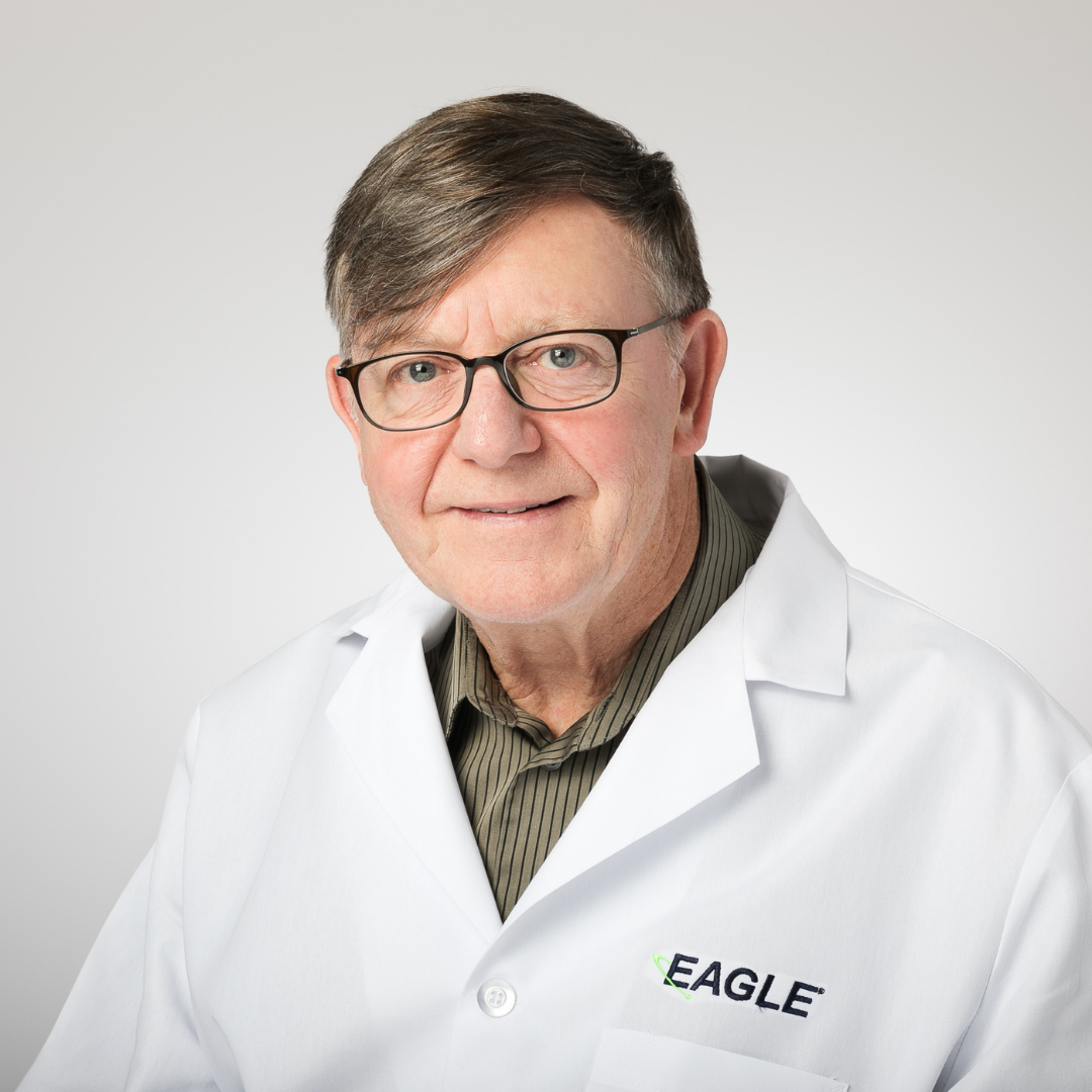Dr. Byrne is smiling while wearing a white Eagle branded lab coat.