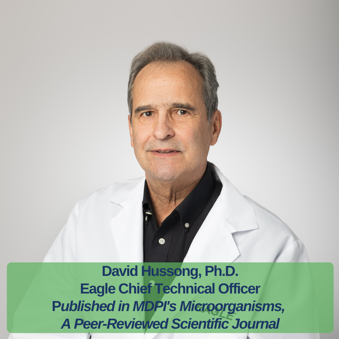 Text reads, "David Hussong, Ph.D. Eagle Chief Technical Officer Published in MDPI's MIcroorganisms, A Peer-Reviewed Scientific Journal." Dr. Hussong is smiling while wearing a white Eagle branded lab coat.