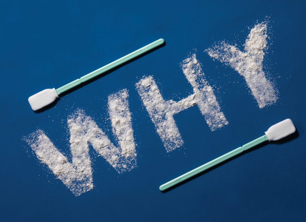 An image of the word "WHY" spelled with white powder with 2 Texwipe® swabs framing it on a blue background.
